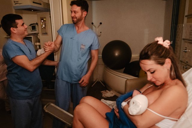 Новоиспеченные родители празднуют появление своего малыша в радостной больничной палате во время спокойных ночных родов